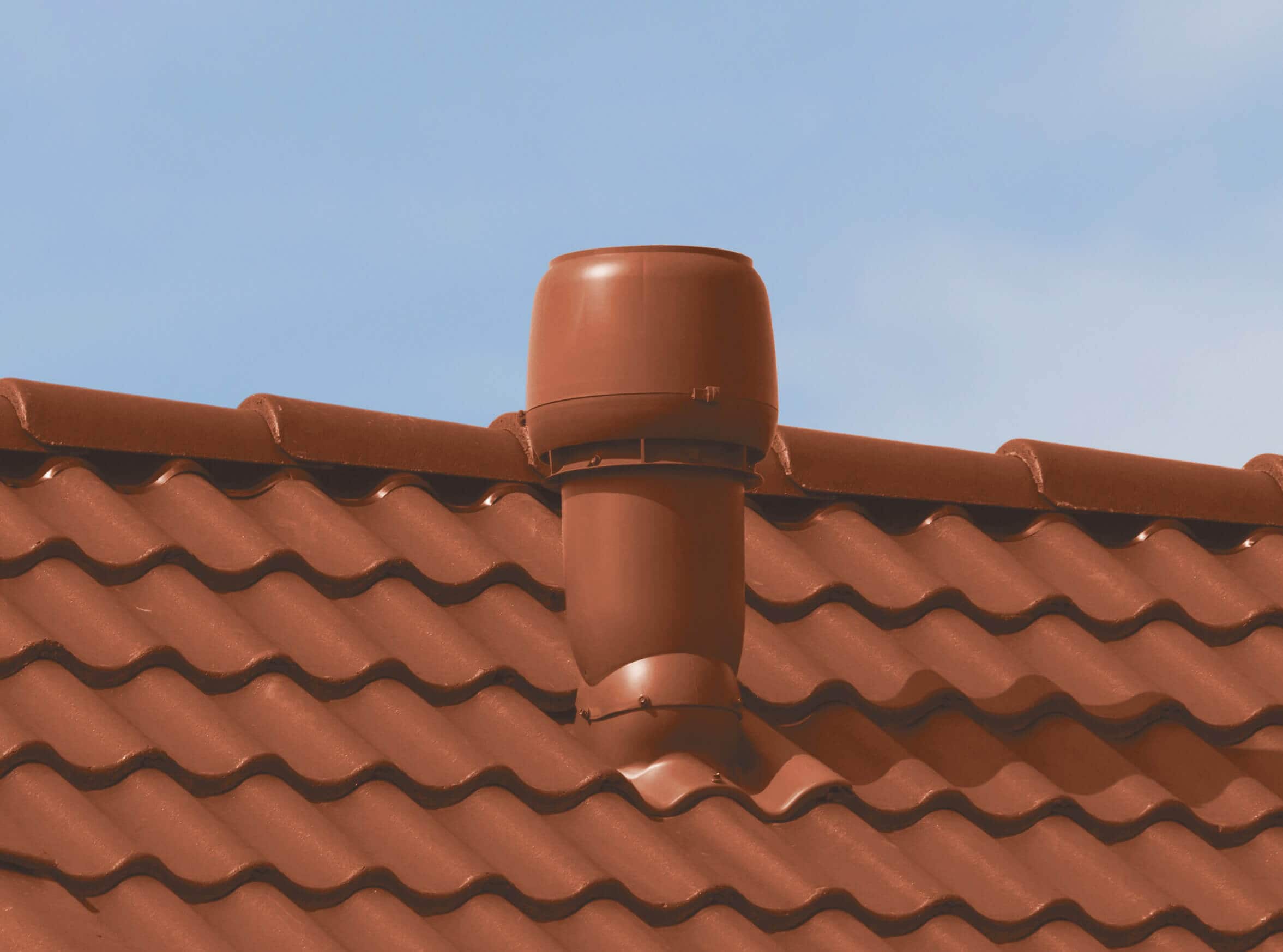Miljöbild på takmotorn Vilpe FKT220P för tvåkupig betongbanna i tegelrött utförande på ett tak med röda takpannor.